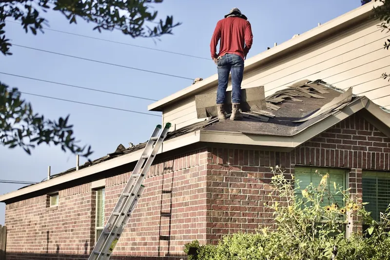 Professional roofer working on a residential roof in Oscar
